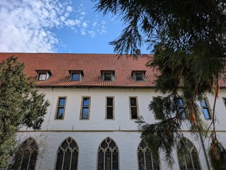 Fototapeta premium Historic monastery building courtyard with classic architecture tiled roof and manicured green garden lawn