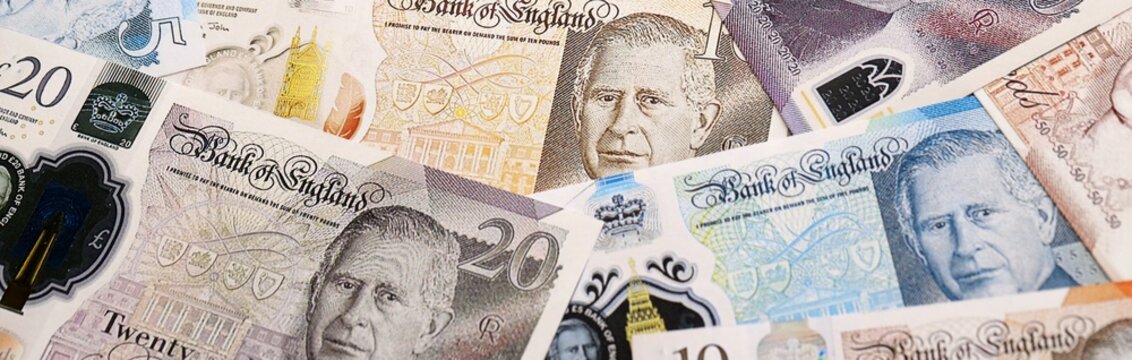 British pound money bills pile on table. United Kingdom banknotes of GBP currency close up.