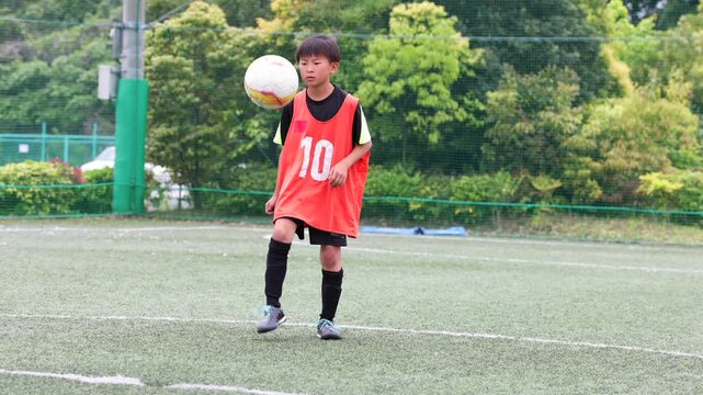 リフティング練習をする少年サッカー選手