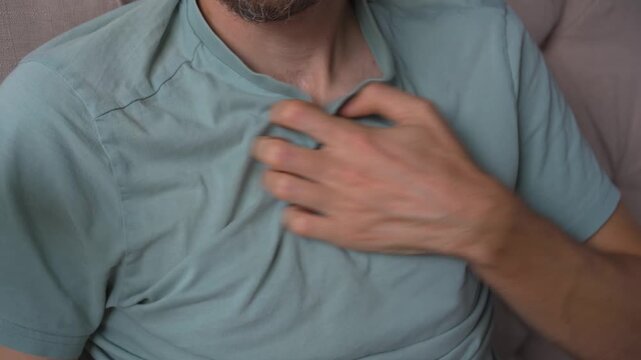 Man scratching his chest with hand, high quality uncompressed audio recording. Subtle skin friction sound and natural gesture. Body sensation, comfort and everyday human behavior concept.