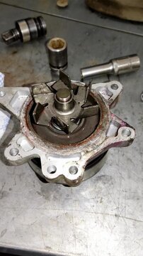 Used car water pump with metal impeller on a workbench