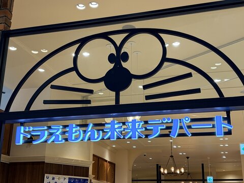 HandM store facade located near the Doraemon Miraitube attraction including themed blue neon signage and character architecture at DiverCity Tokyo Plaza - Tokyo, Japan, February 3, 2026