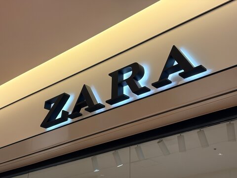 ZARA fashion retail store sign with back-lit 3D logo letters mounted on a modern storefront wall near a Godiva boutique - Tokyo, Japan, February 03, 2026
