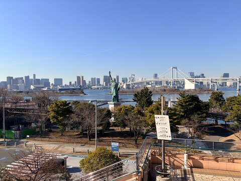 Statue of Liberty replica at Odaiba Marine Park overlooking Tokyo Bay with Rainbow Bridge and Minato district cityscape in the background - Tokyo, Japan, February 4, 2026