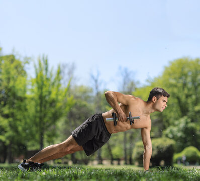 Young man performing a renegade row with a dumbbell