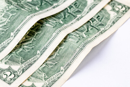 A detailed close-up image of multiple two-dollar bills featuring the portrait of Thomas Jefferson, arranged in an overlapping manner. Two american dollars banknote close up.