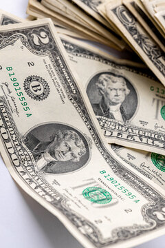 A detailed close-up image of multiple two-dollar bills featuring the portrait of Thomas Jefferson, arranged in an overlapping manner. Two american dollars banknote close up.
