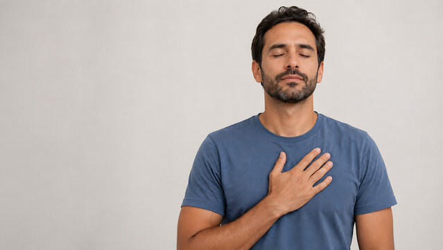 Peaceful man holding hand on chest feeling gratitude and relief
