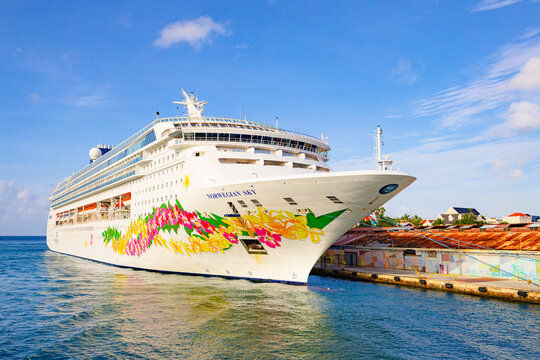 Willemctad, Curacao - 22.03.2026: The Norwegian Sky cruise ship with colorful floral hull art docked at the port terminal under a bright blue sky