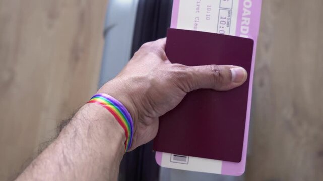 Airport, passport, ticket and rainbow flag wristband in hand, travel bag and check-in. Identity document and person with luggage for immigration and waiting for the flight.