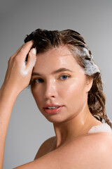Naklejka premium Radiant young woman enjoying hair care in a stylish studio setting