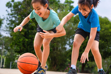 Fototapeta premium Active students practicing basketball drills during physical education class or after school sports program.