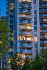 Modern high rise apartment tower with illuminated balconies at twilight © karamysh