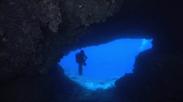 cave diving underwater scuba divers exploring caves and having fun ocean scenery sun beams and rays background