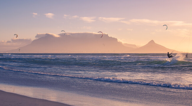 Kitesurfer Riding Breaking Wave with Table Mountain Silhouette at Sunset, Bloubergstrand, Cape Town, South Africa