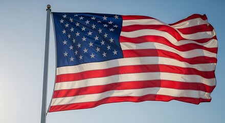 Fototapeta premium Waving United States of America Flag Against a Clear Blue Sky on a Sunny Day