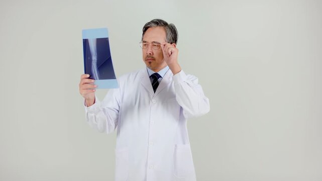 Professional senior doctor looking and analyzing at CT scan xray of patient image, X-ray of foot. Foot pain causes diagnosis and treatment.