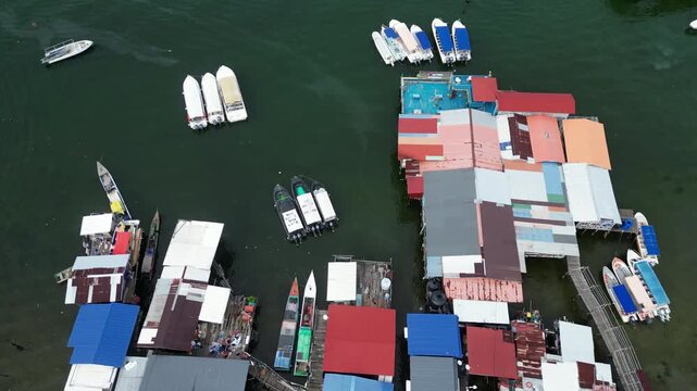 Descending over tour boats anchored at the port with slogans written on it 4k drone