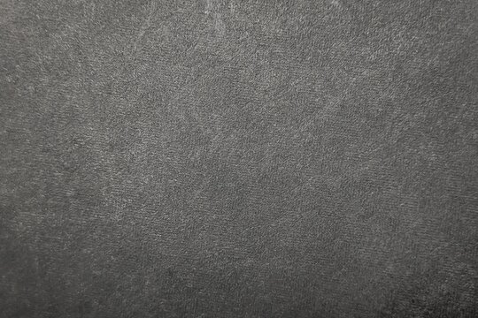 Dark gray textured plastic surface background with grainy matte finish