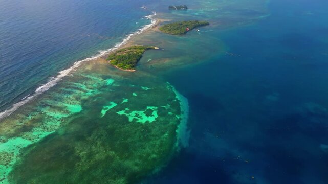 Aerial view of lush tropical cays surrounded by vibrant coral reefs and turquoise Caribbean waters in Guanaja, Bay Islands Department, Honduras.