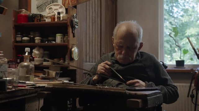 Elderly craftsman working in his old workshop, carefully restoring collectible Japanese bladed weapons