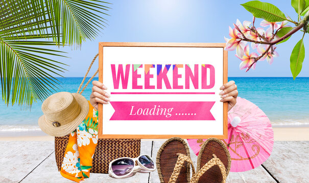 Weekend loading sign with summer set on wooden table over tropical beach background, summer season concept