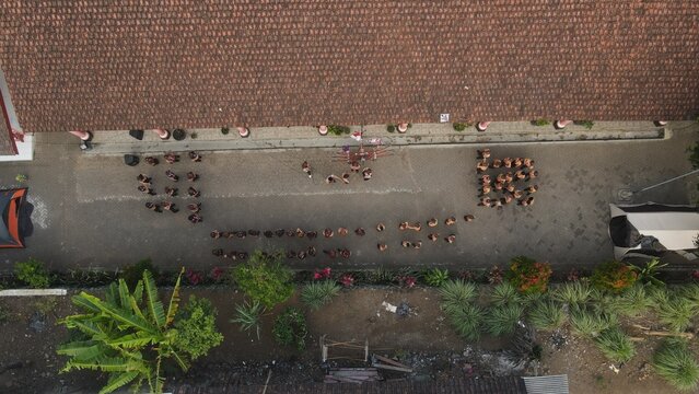 Top-down aerial view of Indonesian scouts in brown uniforms gathering for an outdoor activity.