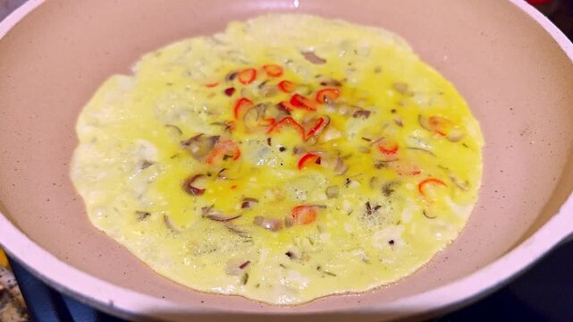 Cooking Spicy Indonesian Omelette Telur Dadar with Chili and Shallots in Frying Pan
