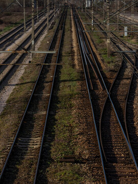Multiple parallel railway tracks stretching into the distance under clear skies at a busy junction