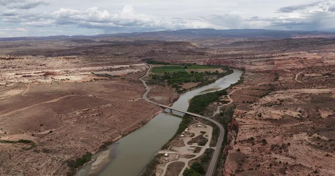 High wide aerial of Dewey Utah with Colorado River with historic bridge in red sandstone canyon