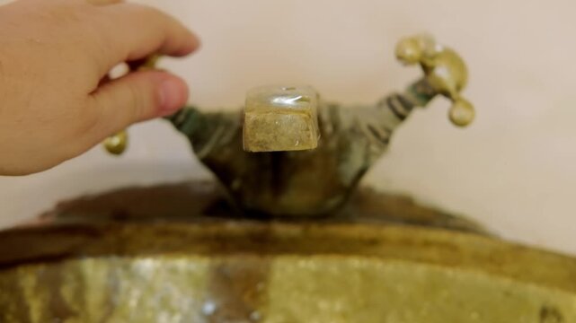 washing hands in Rustic brass sink, morning skincare routine in Moroccan-style interior, Self-care and mindfulness, basic hygiene and cultural touch in Morocco