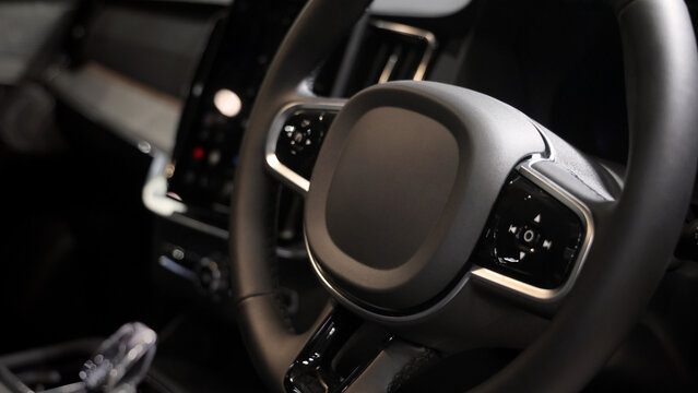 EV Car steering wheel. Modern car interior with luxury steering wheel dashboard and digital monitor controls. Steering wheel and automotive cabin. Car technology comfort and premium design in EV car.