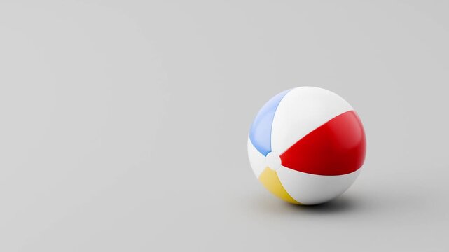 Beach Ball Rolling Slowly from Left and from Right and Stopping on Clean Gray Background with Copy Space