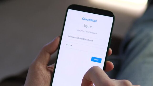 Professional visual of a mobile sign-in screen for a cloud service. Hand typing an email and password to gain access. Great for showcasing modern authentication, online connectivity, and business