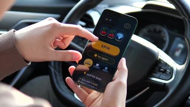 Person playing a mobile slot machine app behind the wheel. Video captures winning a bonus credit and losing spins. Concept of digital entertainment, gambling apps, and risky behavior. Clear smartphone