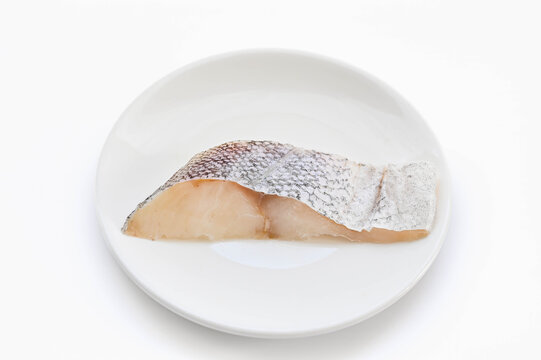 白背景のお皿にのった生の真鱈の切り身