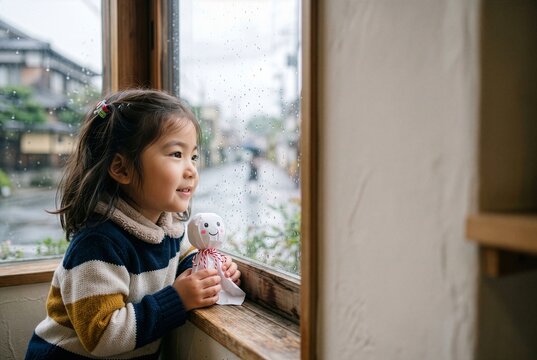 Japanese Child Holding Handmade Teru Teru Bozu, Hoping for a Sunny Day by the Window