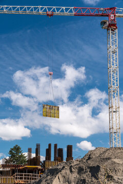 Canada, BC, Richmond.  A section of concrete form being lowered into place by  crane. 