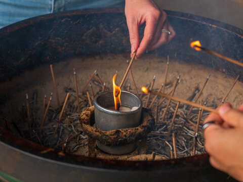 Two Hands Lighting Incense at Japanese Shrine Burner Horizontal Frame