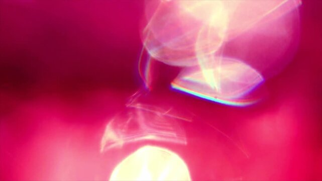 Close-up of glowing light orb reflecting on wet pink surface in low light