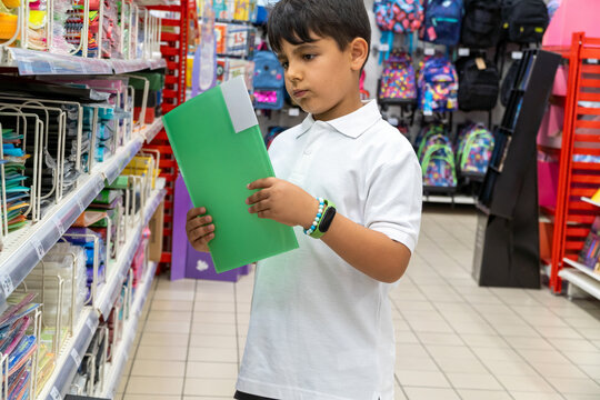student in school uniform choosing school folder on the shopping mall
