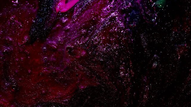 Close-up abstract swirling motion of dark liquid with pink and purple ink diffusion in water
