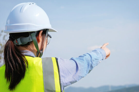 Female civil engineer pointing at outdoor worksite view