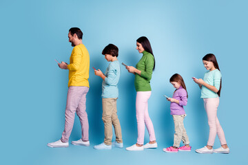 Fototapeta premium Family walking in line using smartphones, parents and children absorbed in mobile screens, modern digital lifestyle and generational tech habits on a blue background