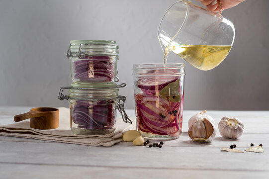 Homemade pickled red onions in jars, bright background