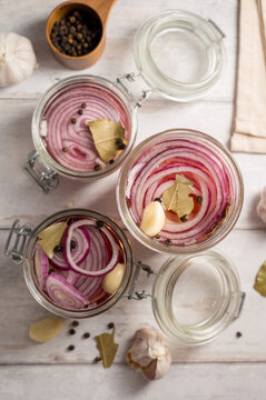 Homemade pickled red onions in jars, bright background