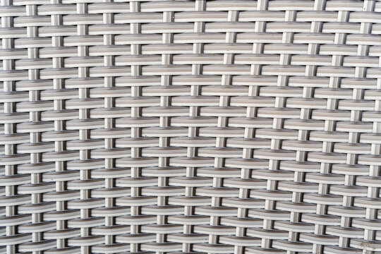 Close-up of woven texture on a synthetic chair seat, showcasing intricate design and craftsmanship, ideal for interior design and furniture presentations.
