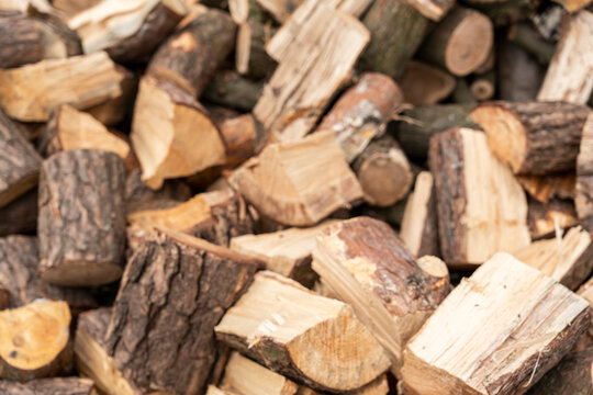 A close-up view of stacked firewood logs showing various textures and colors, ideal for natural resource illustrations or home design concepts.