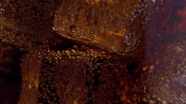 Close-Up of Bubbles Rising in a Cold Beverage with Ice Cubes Under Soft Lighting