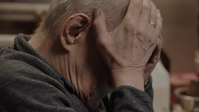 An elderly craftsman working carefully in a small traditional workshop